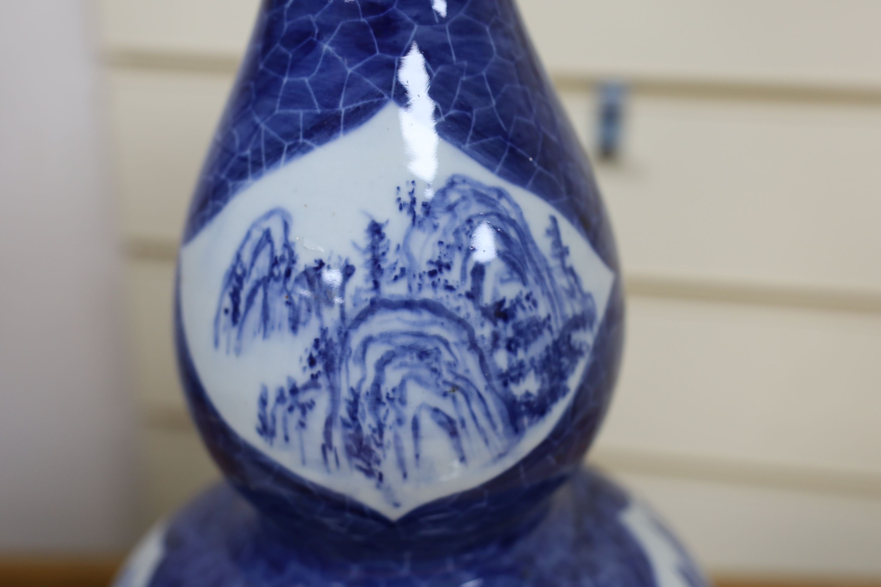 A Chinese blue and white gourd vase with landscape decoration, a similar blue and white sleeve vase and a Japanese Kutani vase